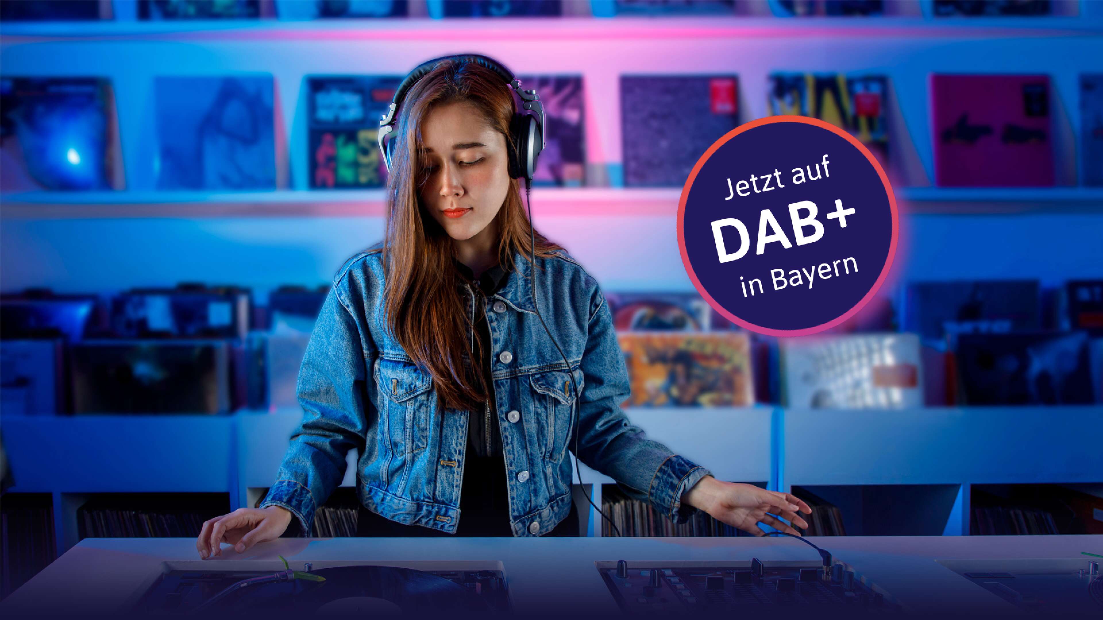 DJane mischt Musik in einem Plattenladen mit Störer "Jetzt auf DAB+ in Bayern"